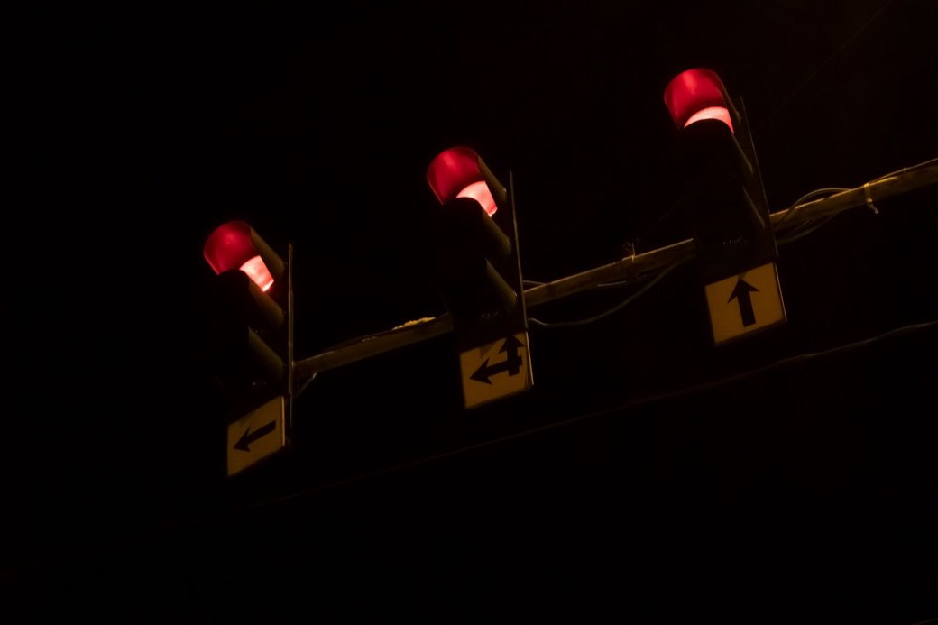 Trois feux de signalisation rouges allumés de nuit