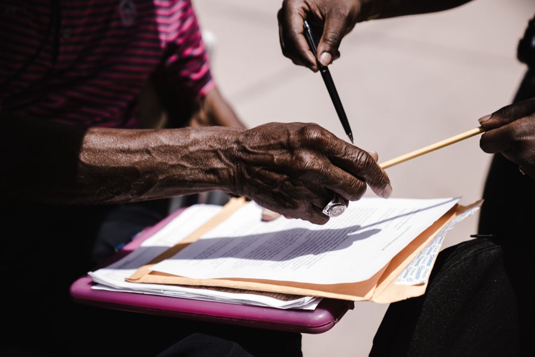 Deux personnes échangeant des documents avec un stylo