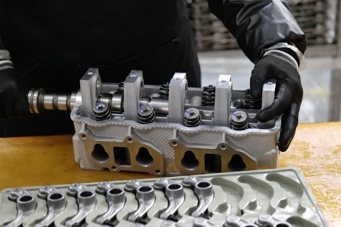 Mécanicien remontant une culasse de moteur automobile en atelier