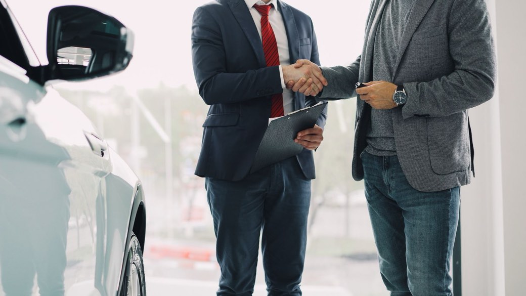 Poignée de main concluant un accord dans une concession automobile
