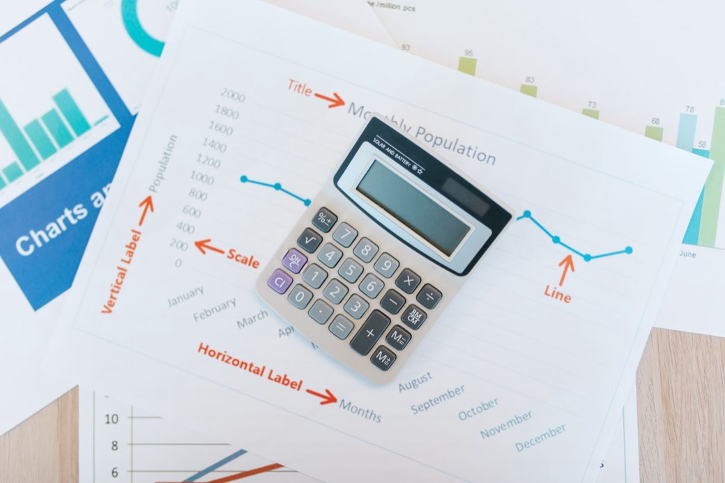 Calculatrice posée sur des documents financiers et des graphiques