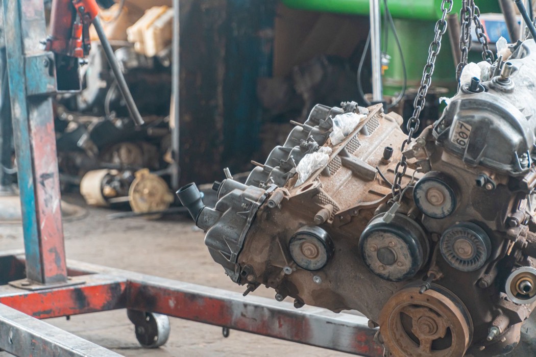 Moteur de voiture suspendu à un palan dans un atelier