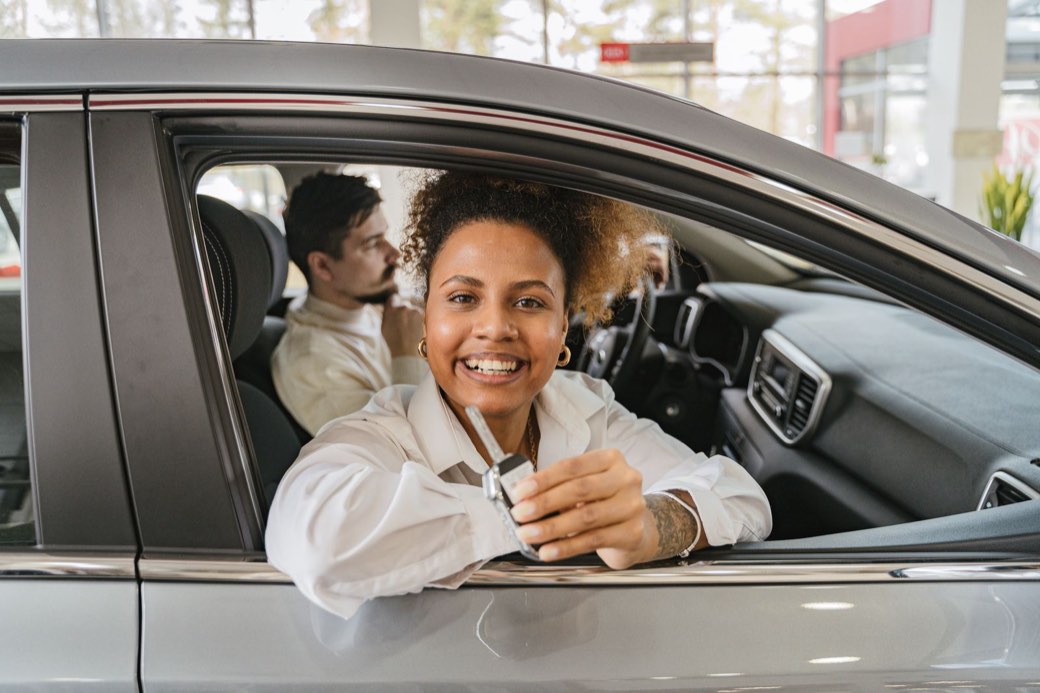 Personnes récupérant les clés d’une voiture chez un concessionnaire