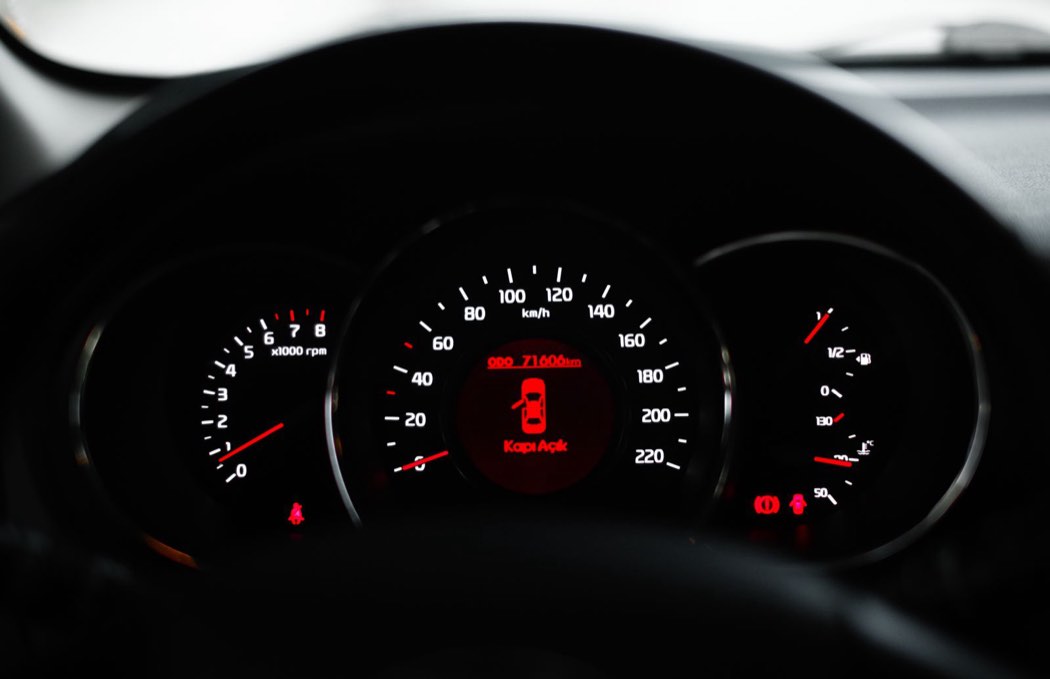Tableau de bord de voiture avec un voyant allumé parmi les cadrans