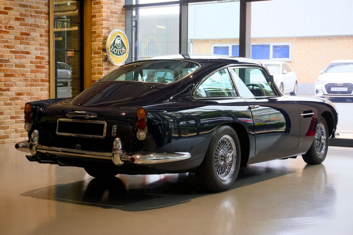 Aston Martin DB5 vue de trois quarts arrière dans un showroom