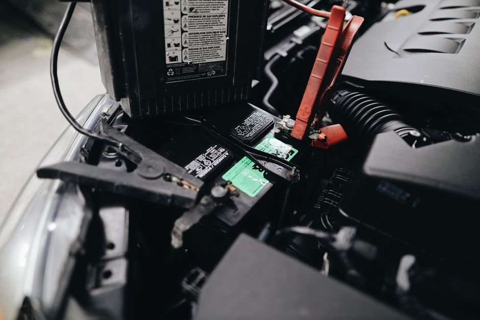 Batterie de voiture reliée à des câbles dans le compartiment moteur