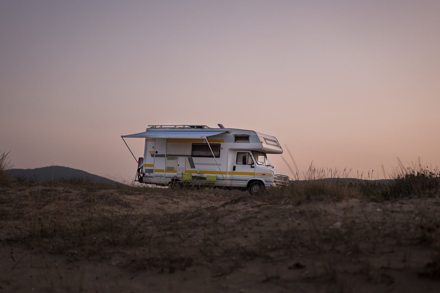 Camping-car stationné en autonomie au bord de la mer au crépuscule