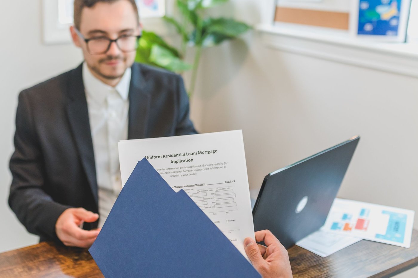 Conseiller et cliente examinant un dossier de financement sur un bureau