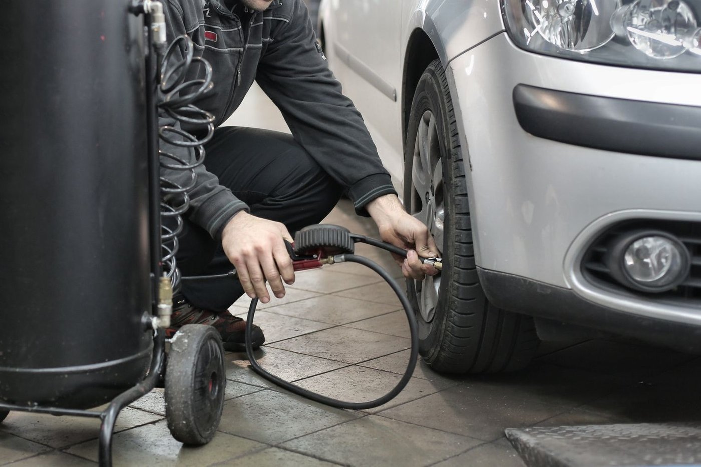 Compresseur d'air d'atelier branché sur un pneu de voiture