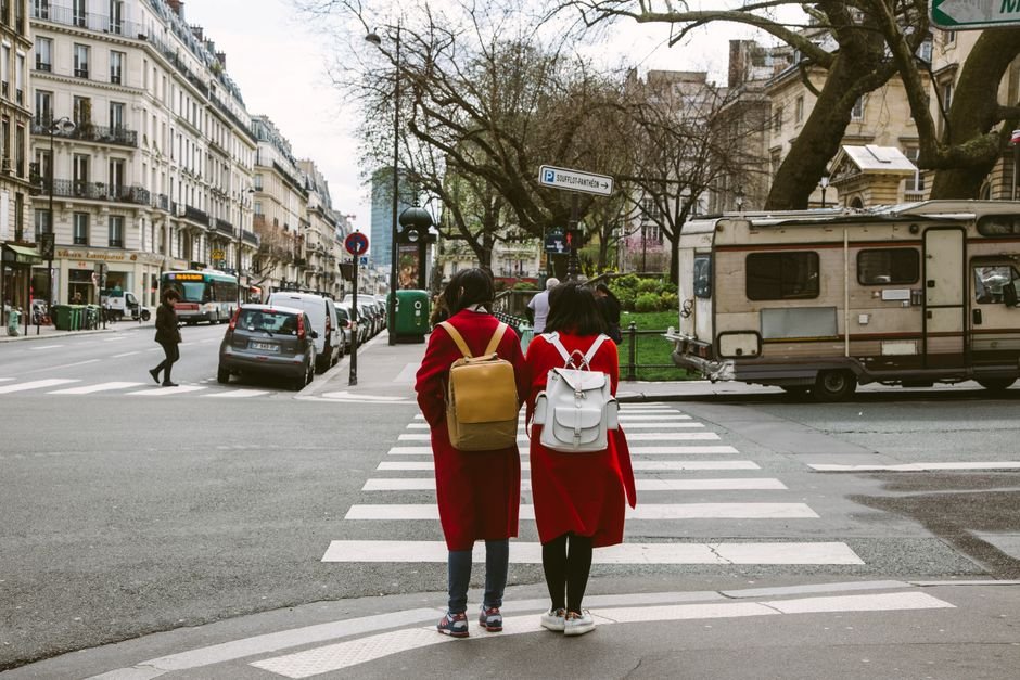 Piétons traversant une rue de Paris devant les voitures arrêtées