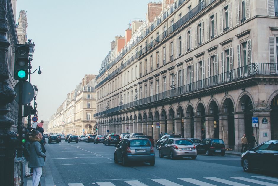 Voitures circulant sous les arcades d'une avenue parisienne