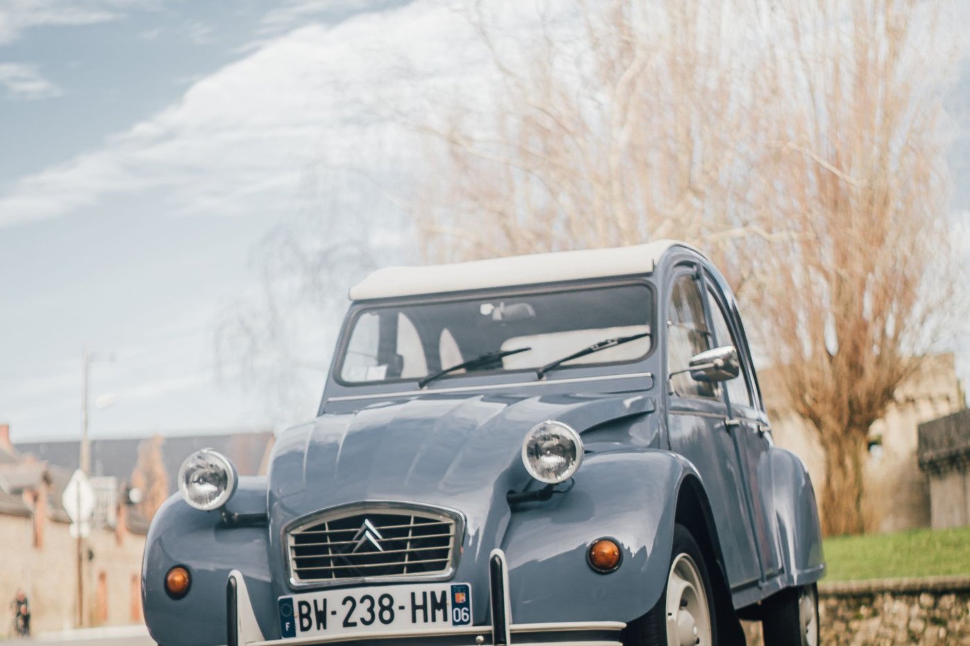 Citroën 2CV grise garée au bord d'une route