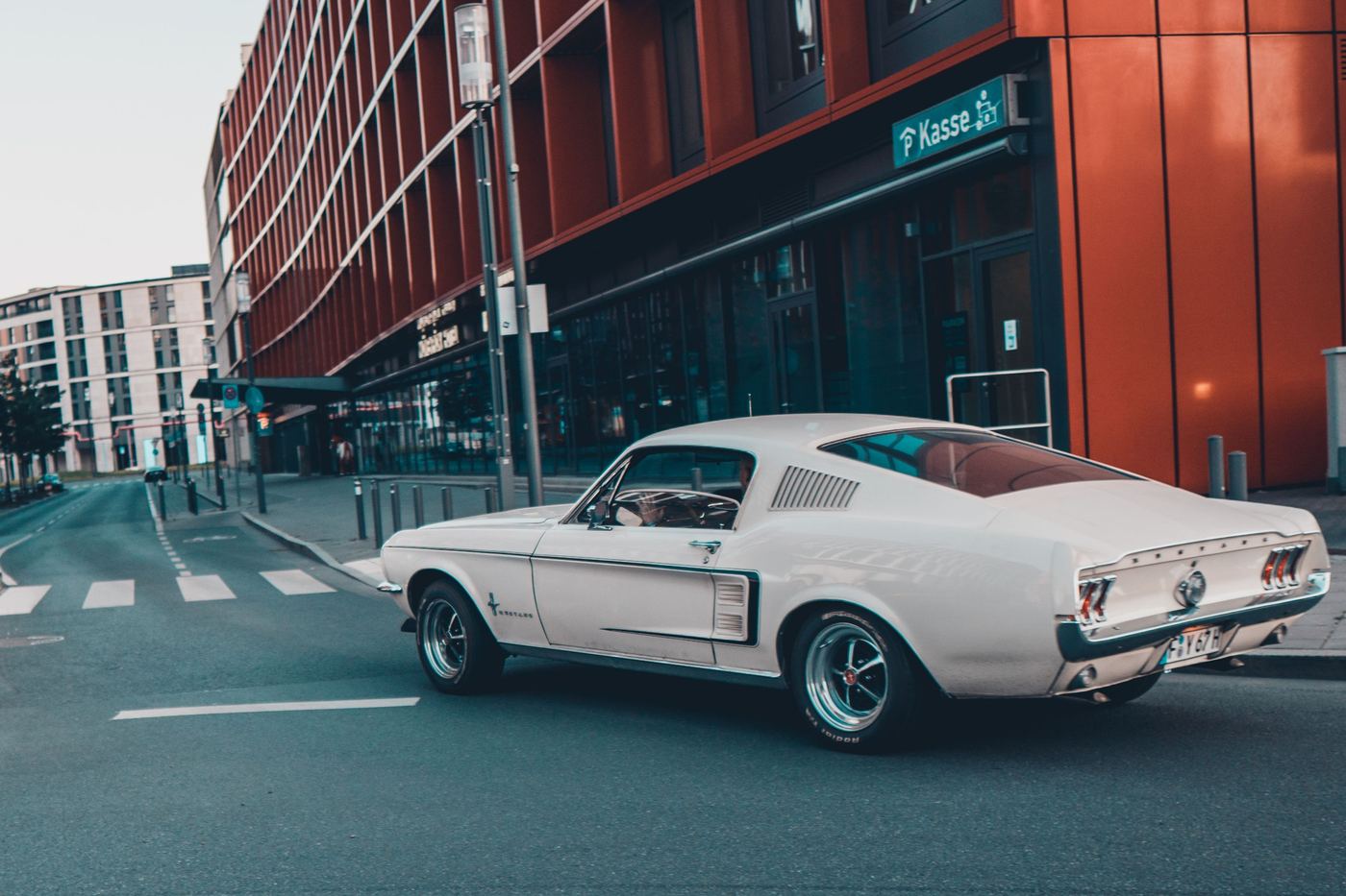 Mustang Fastback 1967 blanche vue de trois quarts arrière en ville
