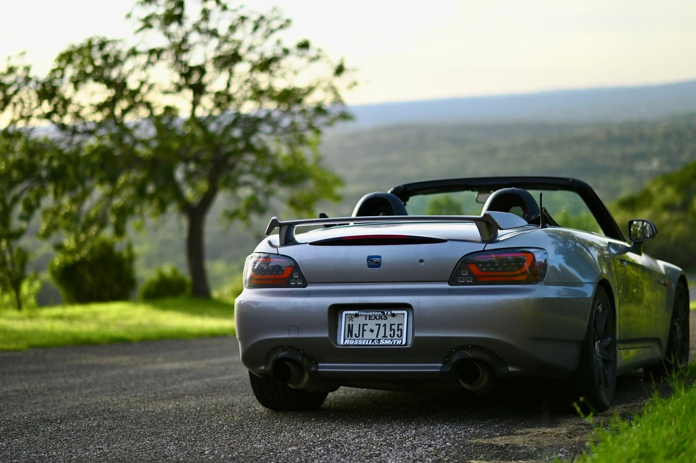 Honda S2000 grise vue de l'arrière, capote ouverte, avec aileron