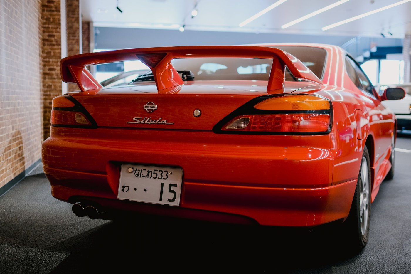 Arrière d'une Nissan Silvia S15 rouge avec son aileron et sa plaque japonaise