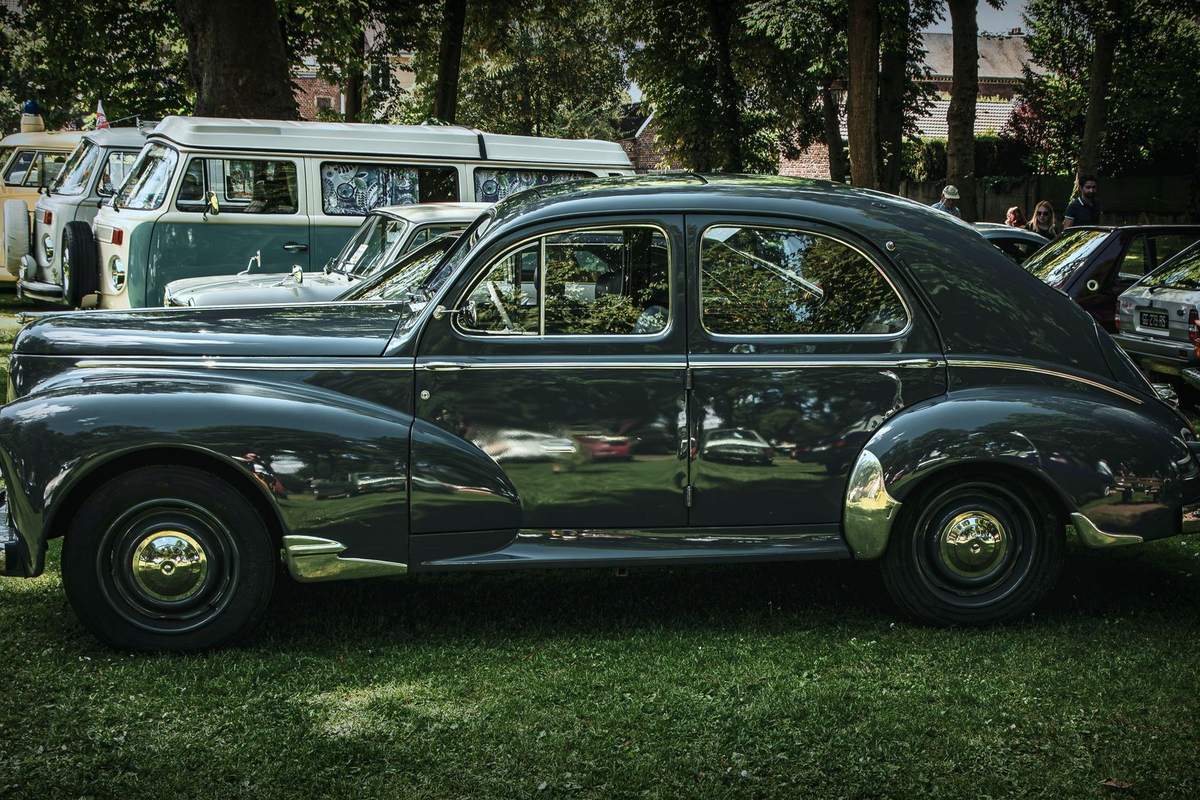 Peugeot 203 berline vert foncé vue de profil dans un rassemblement