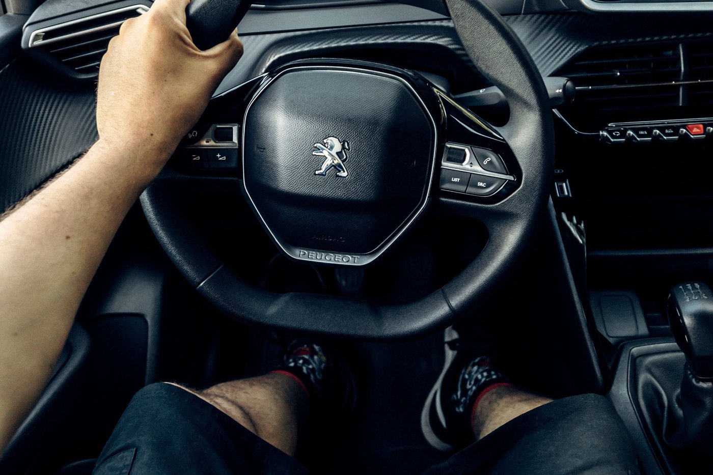 Volant Peugeot i-Cockpit tenu par un conducteur en ville