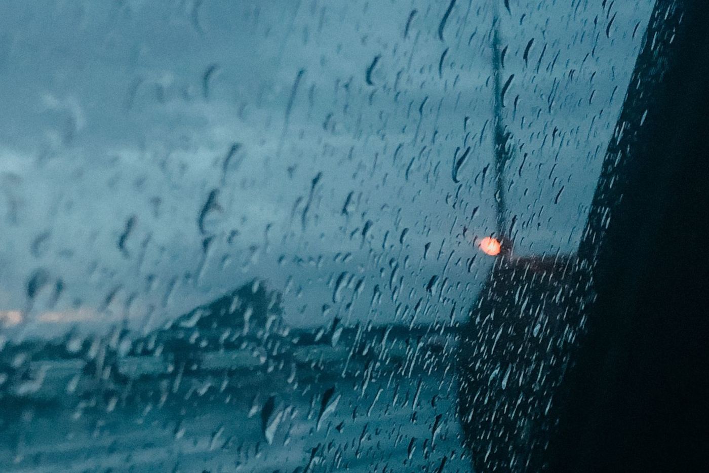 Gouttes de pluie sur une vitre latérale vue de l'habitacle