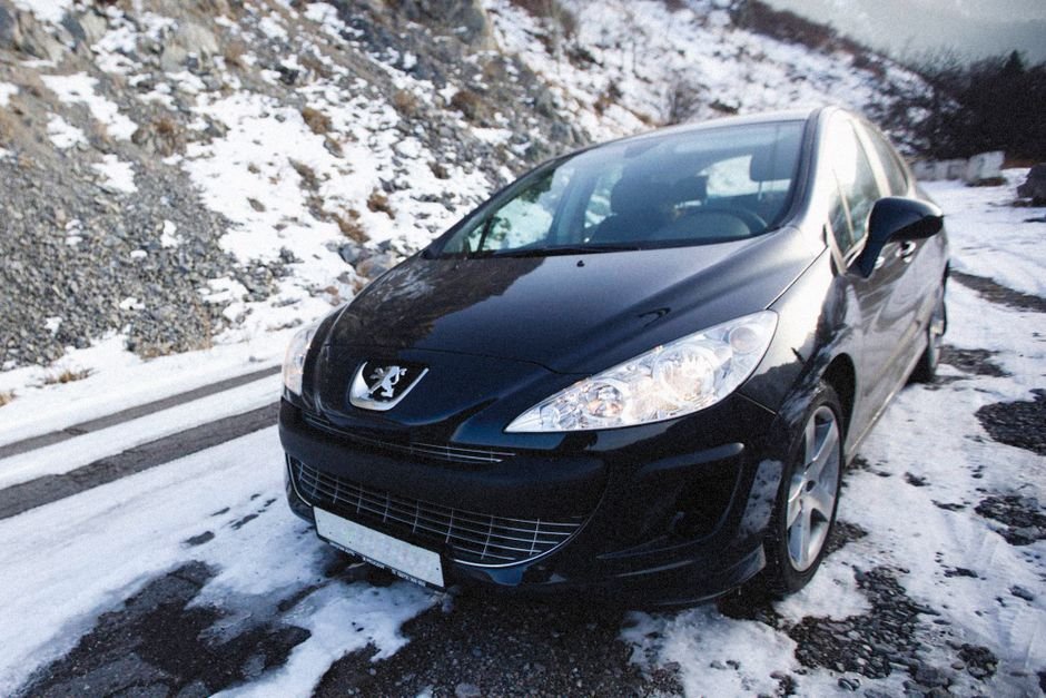 Voiture garée sur une route de montagne enneigée