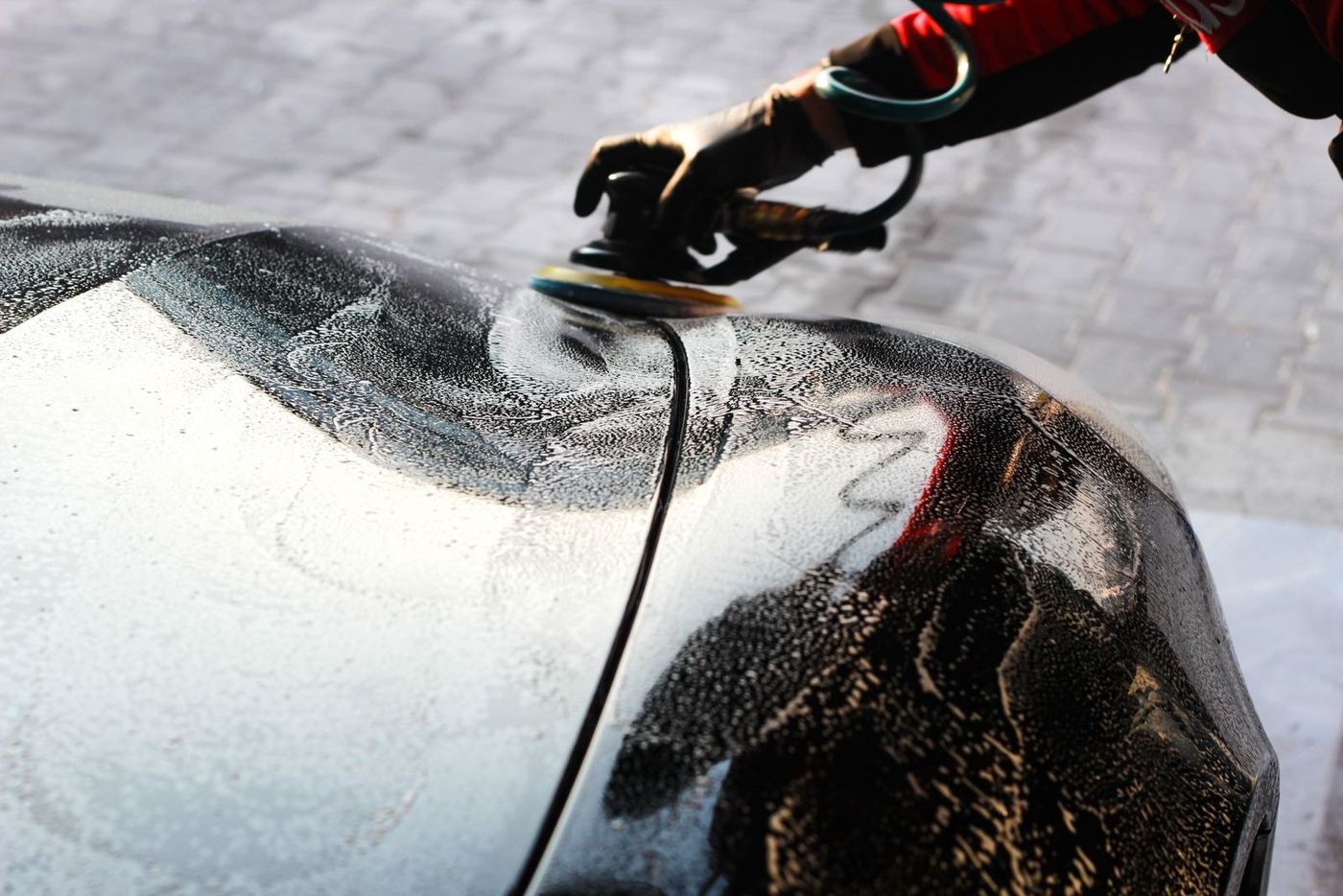 Polisseuse en action sur le capot d'une voiture
