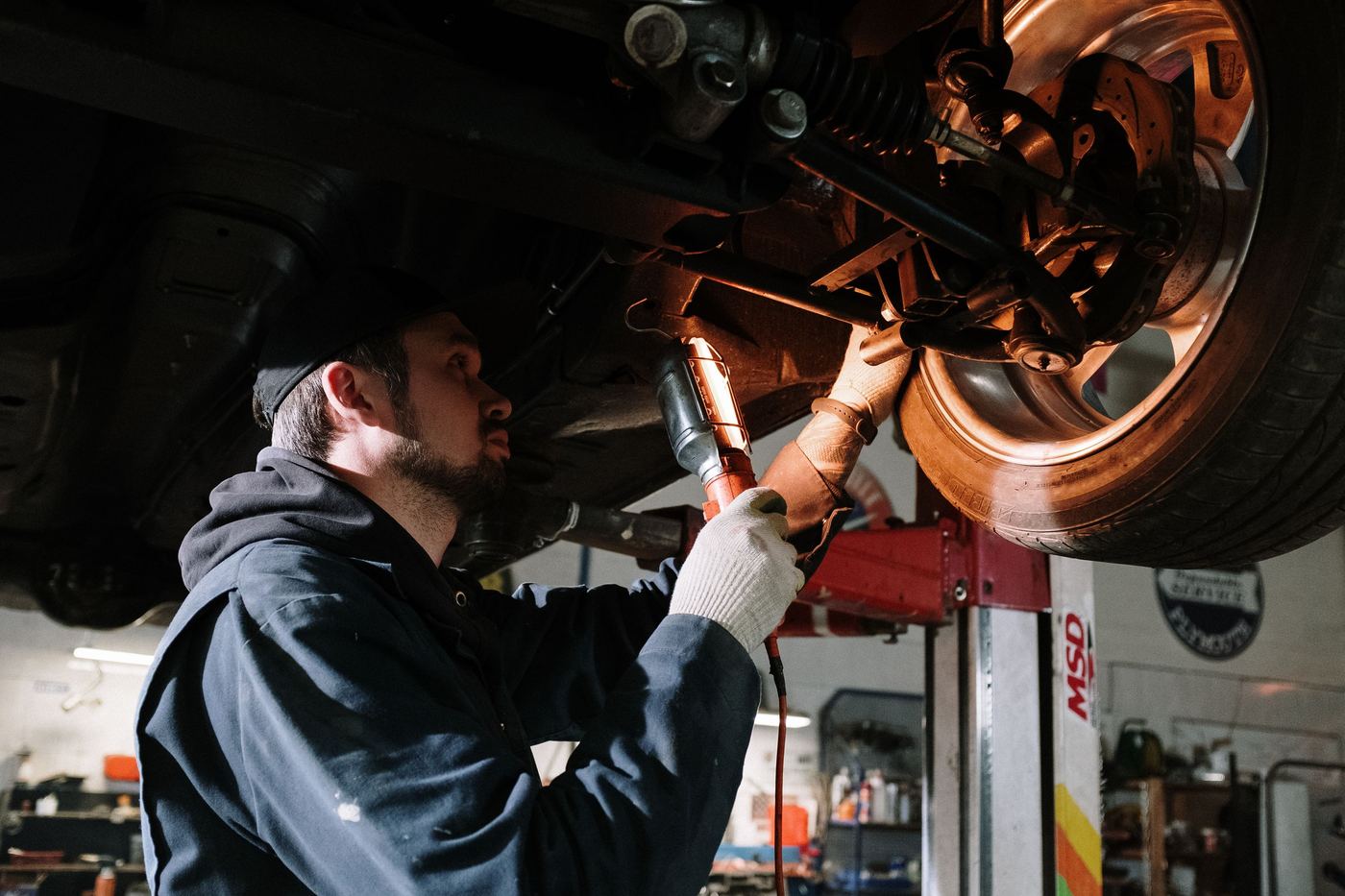 Contrôleur inspectant le châssis d'une voiture à la lampe