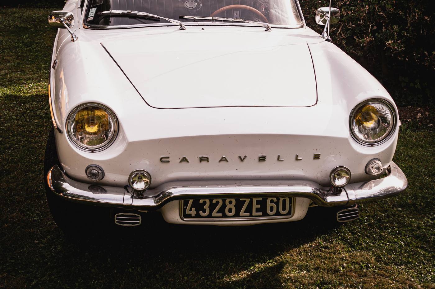 Face avant d'une Renault Caravelle blanche avec son inscription sur le capot