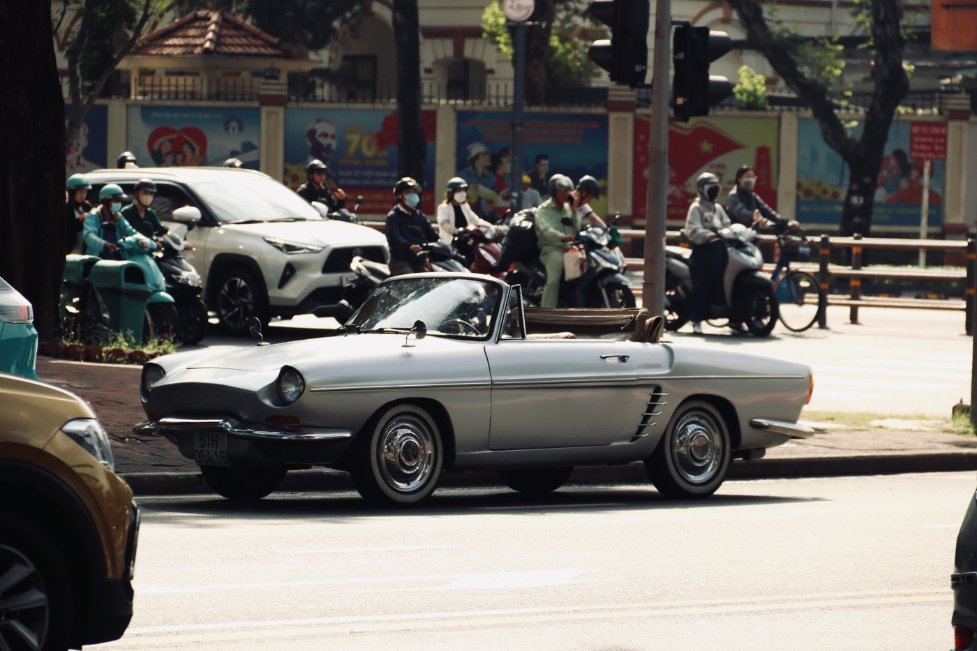 Renault Floride cabriolet gris clair dans la circulation d'une ville d'Asie