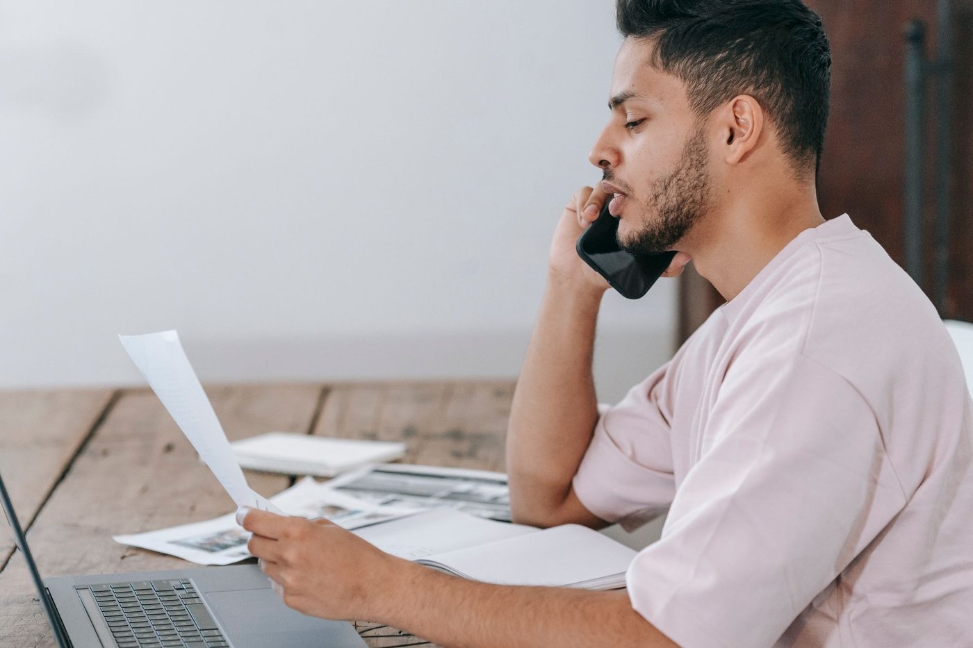 Homme au téléphone lisant un document