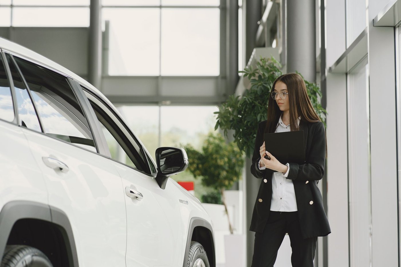 Cliente examinant un véhicule dans le hall d’une concession automobile