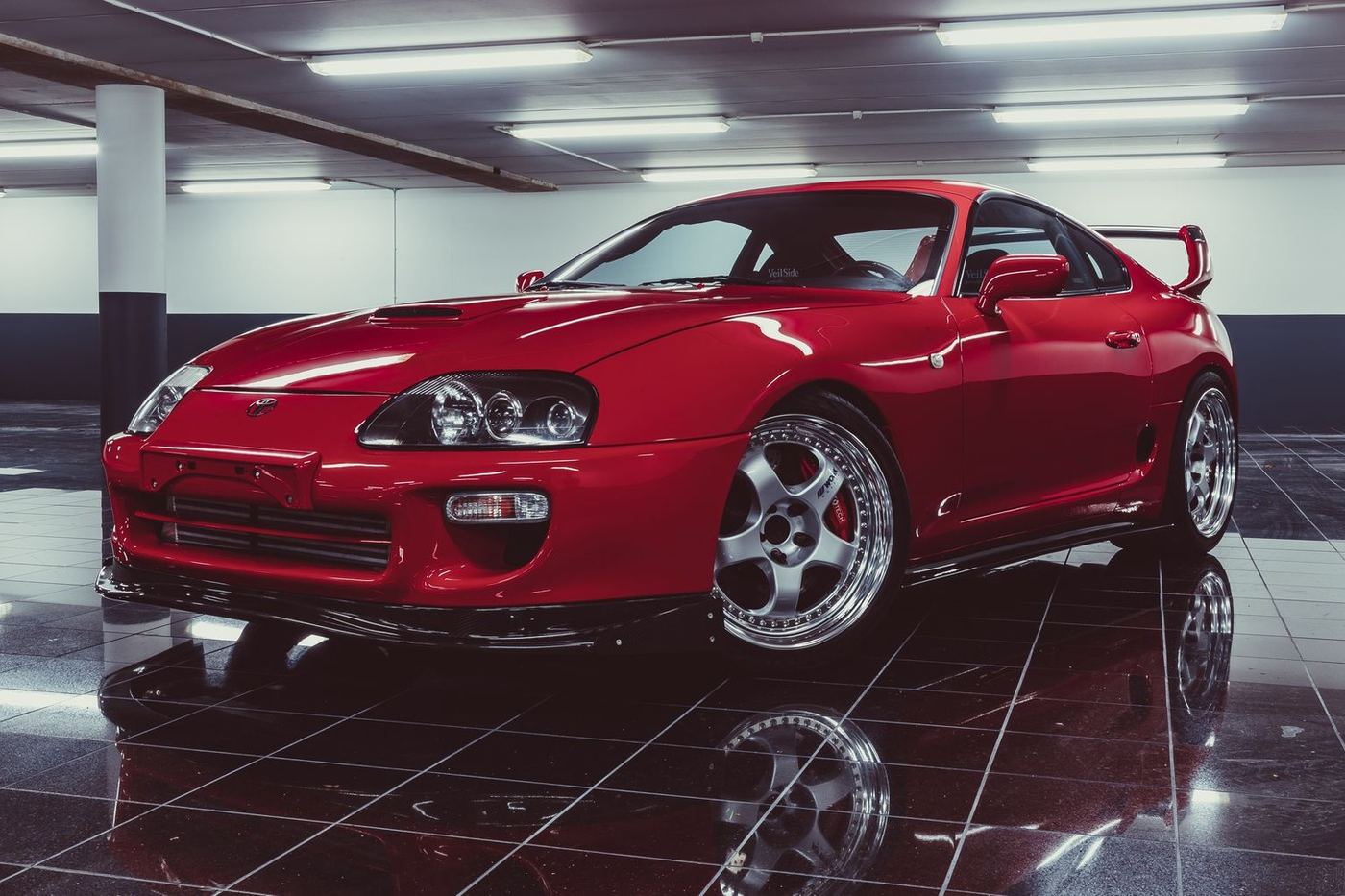 Toyota Supra MK4 rouge et son aileron surdimensionné