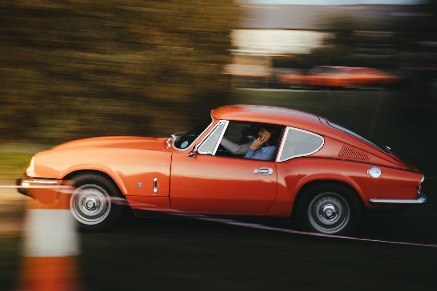 Triumph GT6 rouge en mouvement, le coupé dérivé de la Spitfire