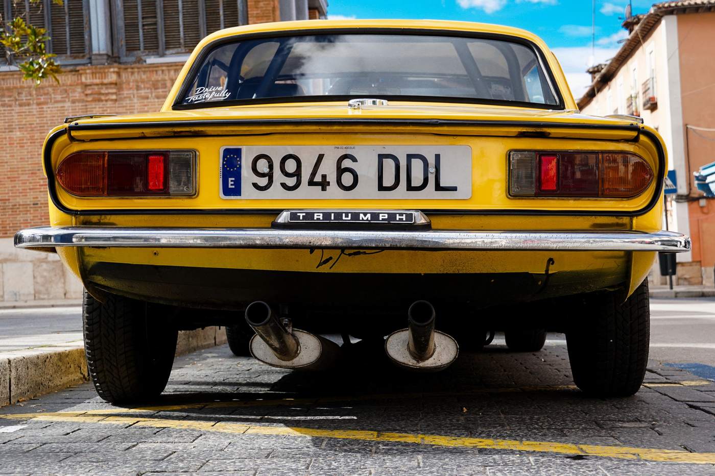 Arrière d'une Triumph Spitfire 1500 jaune avec sa double sortie d'échappement