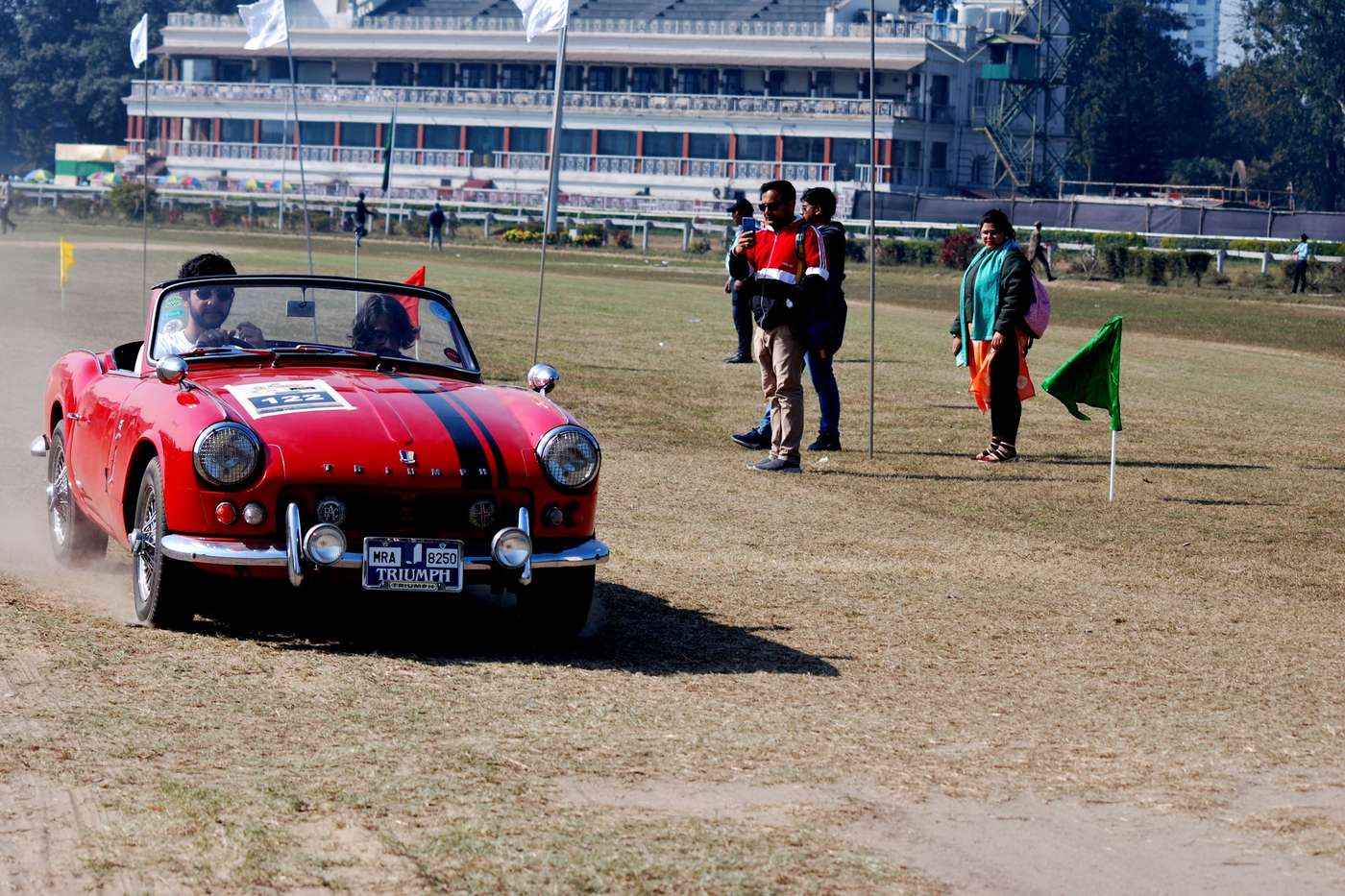 Triumph Spitfire Mk2 rouge à bande noire lors d'un rallye de régularité
