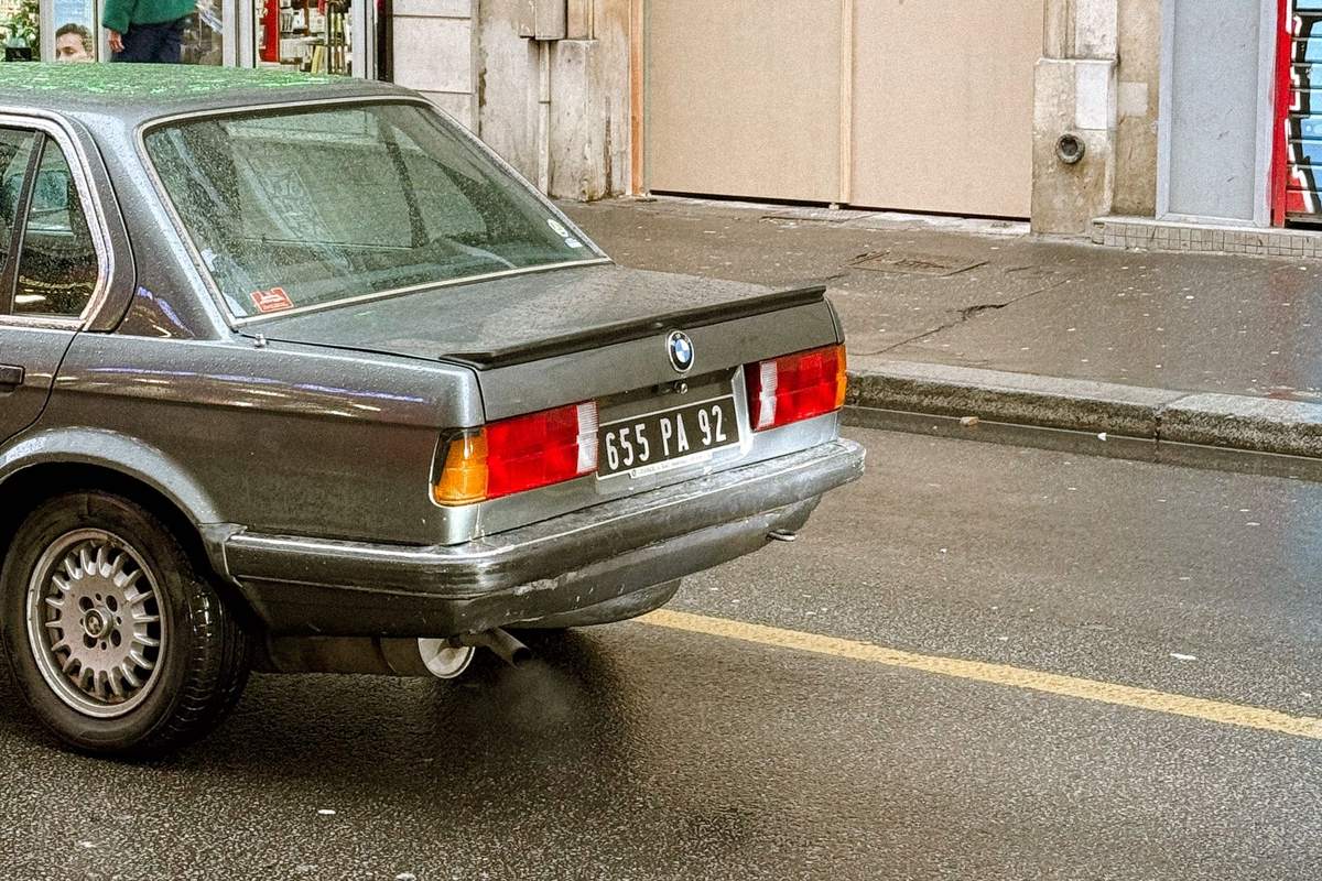 BMW serie 3 E30 grise garee dans une rue francaise
