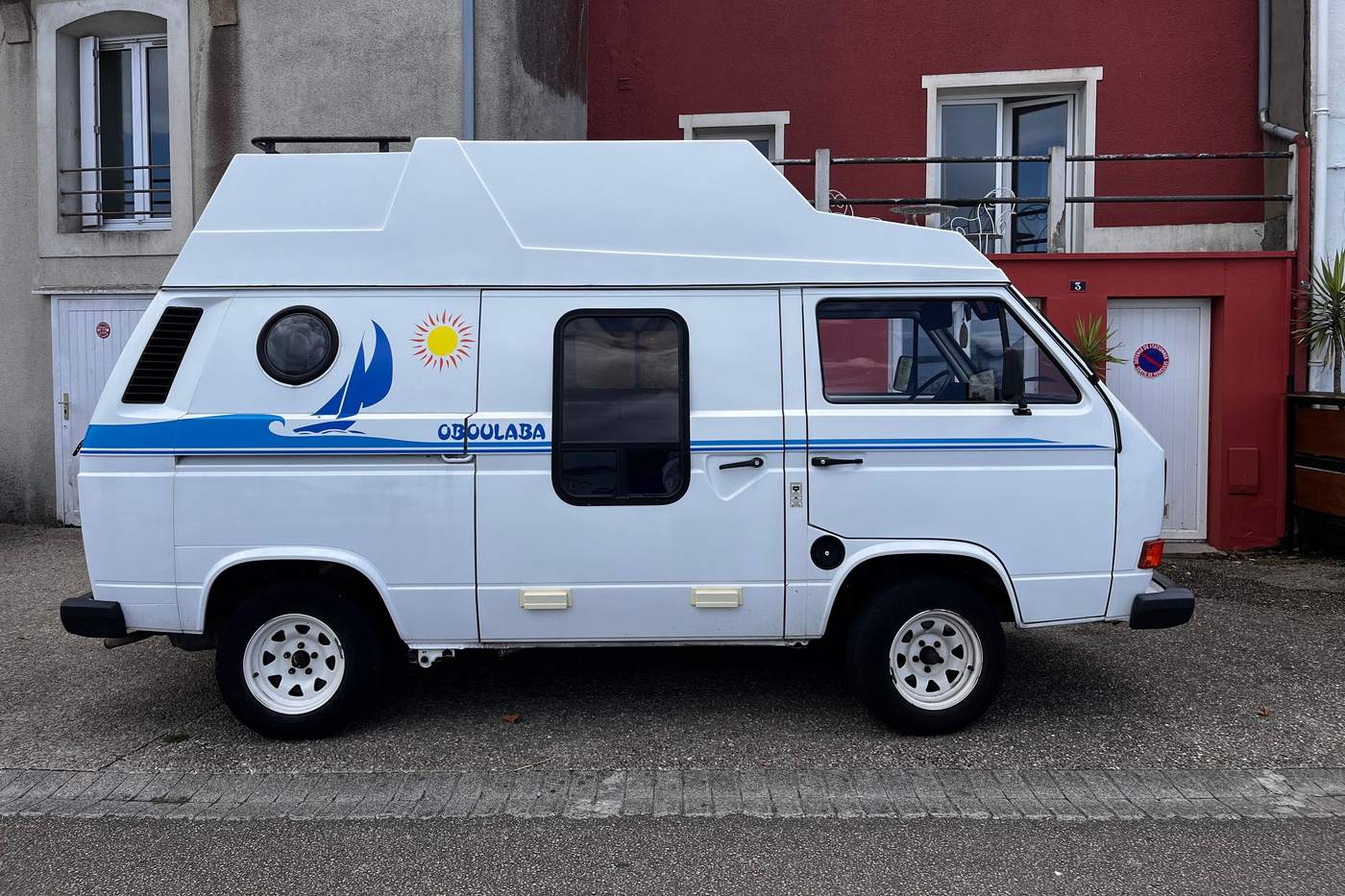 Volkswagen T3 blanc aménagé en camping-car avec toit surélevé fixe