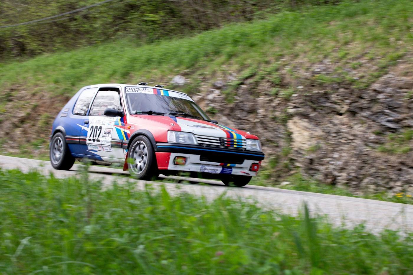 Peugeot 205 de rallye en action sur une route de montagne