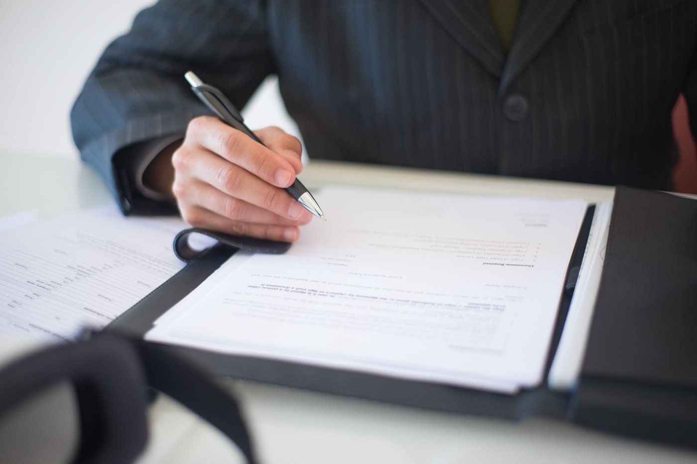 Signature d'un document avec un stylo, gros plan sur la main